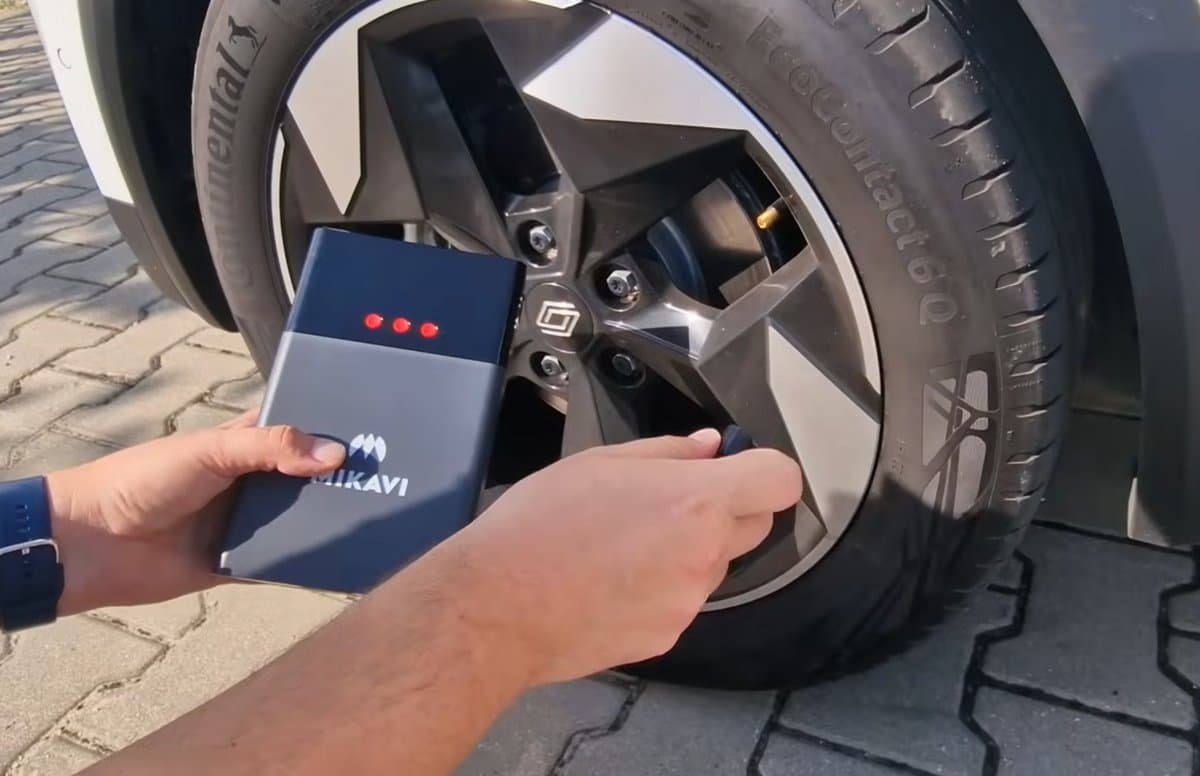 Jump starter Mikavi z wbudowanym kompresorem podłączony do zaworu koła samochodowego